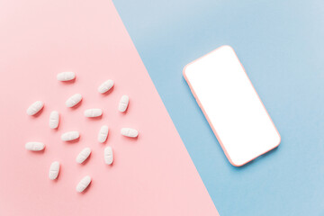 medicine capsules next to a mobile phone. Telephone medical attention