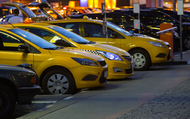 Fototapeta na wymiar Yellow taxi cars at night in parking in city