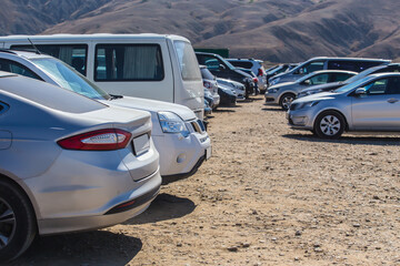 Fototapeta na wymiar Cars parked outside the mountain range