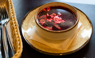 Appetizing hot borscht with sour cream in bowl