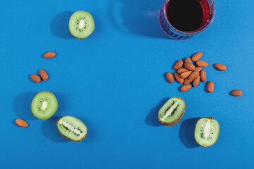 Treat insomnia with healthy sleep foods almonds, cherry juice and kiwi. Layout on blue background. Top view with copy space