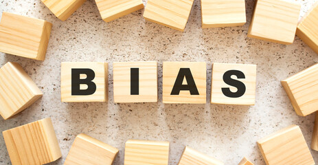 The word BIAS consists of wooden cubes with letters, top view on a light background.