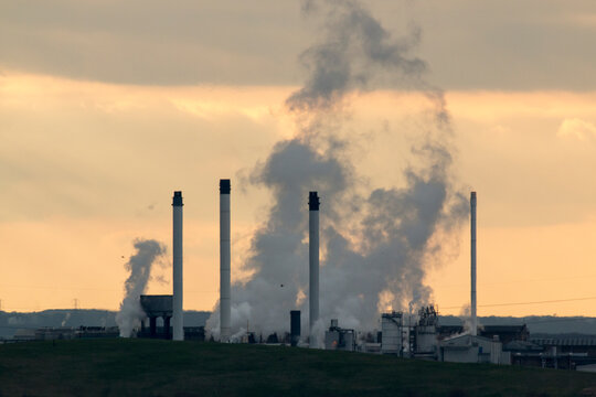 Industrial chimney unit, spewing smoke and steam, photographed Isle of Grain, Kent