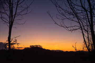 beautiful sunset in the mountains with beautiful colors in a natural environment with trees