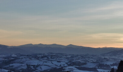 Valli innevate e montagne dell’Appennino al tramonto
