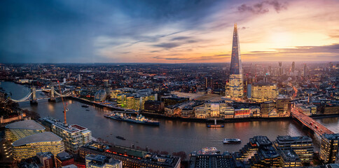 Panoramic view to the illuminated skyline of London, United Kingdom, during sunset time with sun...