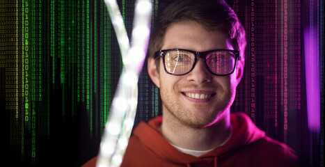 virtual reality, technology and programming concept - portrait of smiling young man in glasses over ultra violet neon lights and binary code on dark background