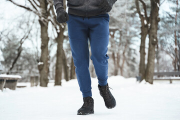 Jogger man running in winter city park