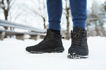 Man wearing black sneakers in winter city park