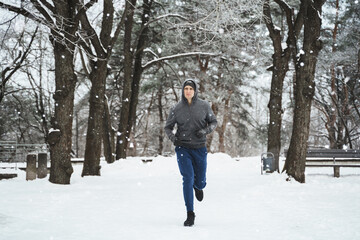 Young jogger man during his workout in winter park