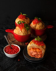 filo fish patties with salmon and cheese on a black background