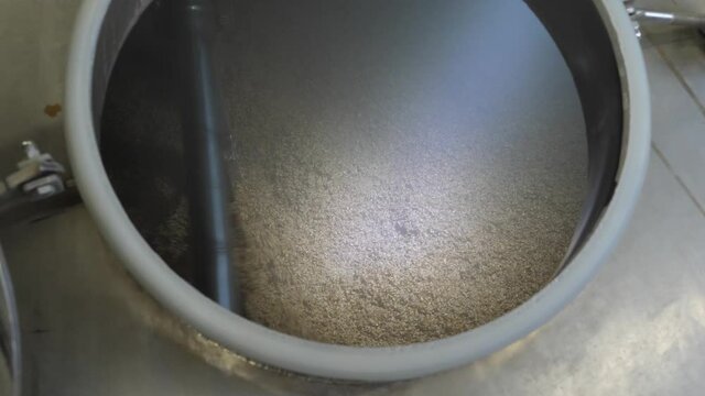 Wort mashing and boiling machine at work. Stirrer mixes malt