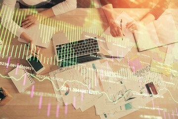 Double exposure of woman hands working on computer and forex graph hologram drawing. Top View. Financial analysis concept.