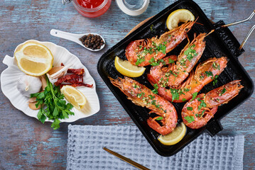 Grilled large queen shrimps with lemon and spices on the grill pan