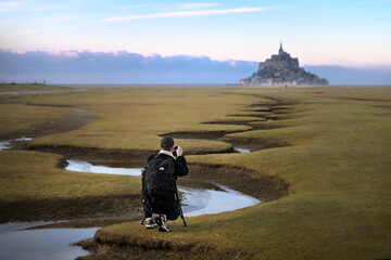 Photographer shooting Mont St Michel in front of famous meanders