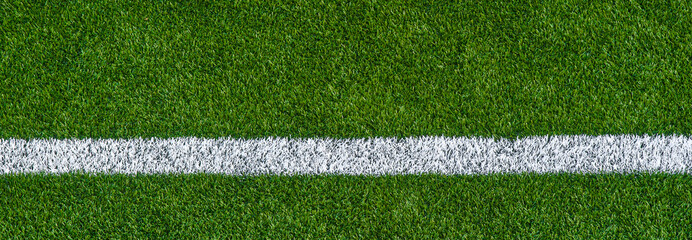 Green synthetic grass sports field with white line shot from above. Sports background for product display, banner, or mockup.