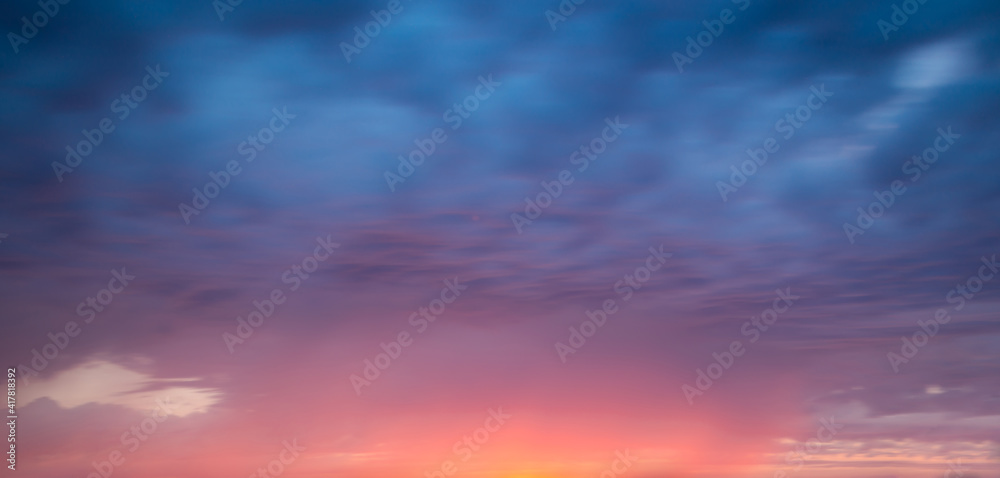 Wall mural pink and blue dramatic sky with clouds at sunset, panoramic nature background