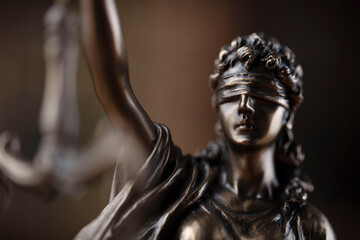 Law concept. Lawyer office. Themis statue on the shelf with legal books background. 