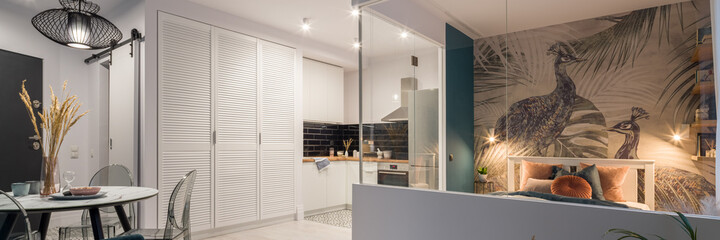Small studio apartment with lights on, panorama