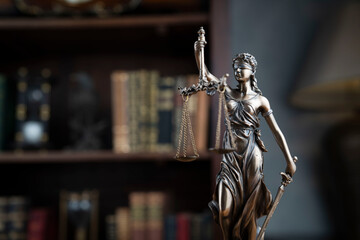 Law concept. Lawyer office. Themis statue on the shelf with legal books background. 
