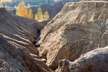 Fototapeta na wymiar Konduki, Tula region, Romancevskie mountains, Abandoned Ushakov quarries. The mud erosion of the soil looks like mountains. The area is overgrown with young birches. Beautiful natural landscape
