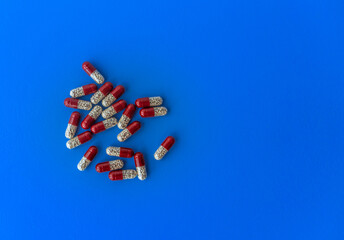 Various tablets and capsules, syringe, protective masks, on a blue background