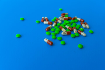 Various tablets and capsules, syringe, protective masks, on a blue background