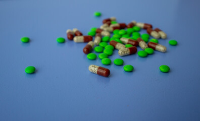 Various tablets and capsules, syringe, protective masks, on a blue background