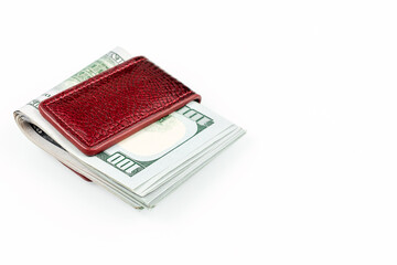 Several one hundred dollar bills folded in half. Dollars clamped by a money clip