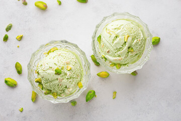Obraz premium Top view pistachio ice cream in glass bowls and nuts