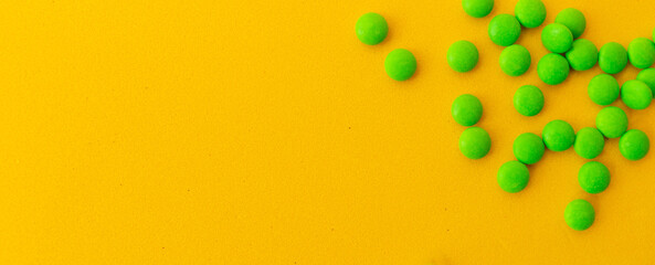 green pills on a yellow background