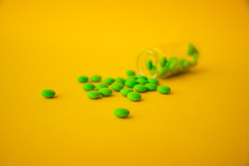 green pills on a yellow background