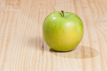Tasty green apple; photo on wooden background.