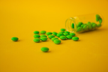 green pills on a yellow background