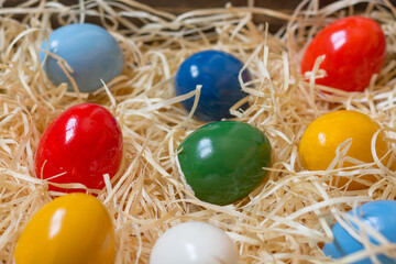 Fototapeta na wymiar Colorful painted easter eggs in a wooden box with straw. Closeup.