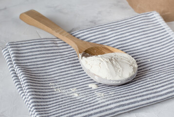 Crumbly xanthan gum in a wooden spoon.