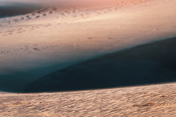 Closeup orange nature texture of the sand and dunes rippled surface, top angle view. Desert background. Play of light and shadow