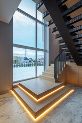 Obraz premium Wooden staircase with illumination in luxury private house. Interior.