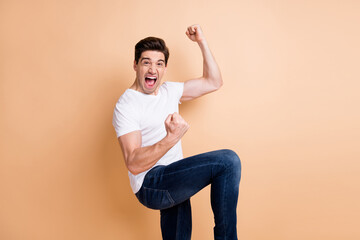 Fototapeta na wymiar Profile side photo of crazy happy young guy raise fists champion wear jeans isolated on beige color background