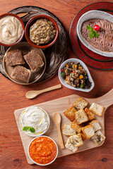 .Meze is an oriental set of appetizers served in small bowls with babaganoush, curd, hummus, muhammara and kibbeh