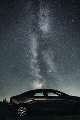 Fototapeta na wymiar Silhouette of Car under beautiful night sky with stars and amazing Milky way galaxy. Side view