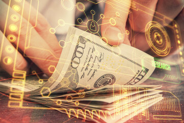 Double exposure of technology drawing hologram and us dollars bills and man hands. Data concept