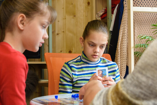 An Adult Explains To Children How To Play A Board Game