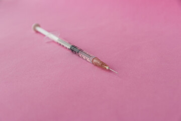 syringe on a pink background close-up 