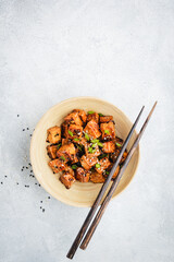 Marinated fried tofu cubes in bamboo bowl. Healthy vegan asian meal