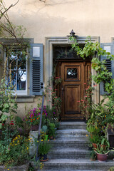 Verwunschene Haustüre aus Holz mit Pflanzen im Vorgarten