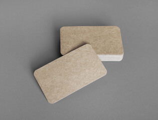 Photo of blank kraft business cards on gray paper background. Template for ID.