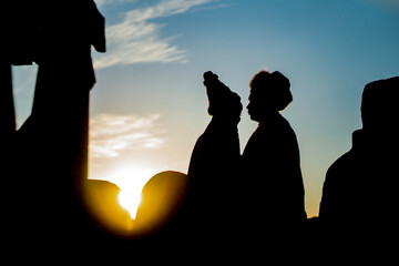 man and woman in national Kazakh costumes against the background of sunset