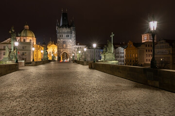 Fototapeta na wymiar paving and stone tower on Charles Bridge on Vltava river at night in the center of Prague