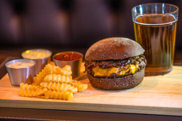 Gourmet cheeseburger with fries and soda in composition top view